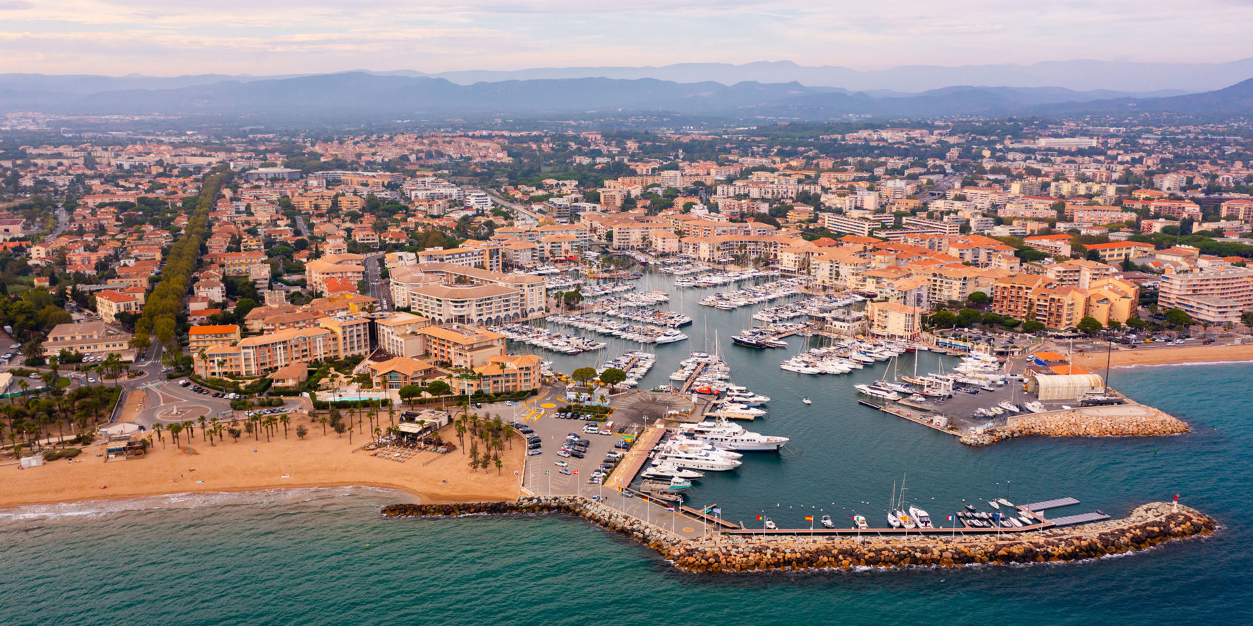 Aerial cityscape of France city Frejus with yachts in harbor