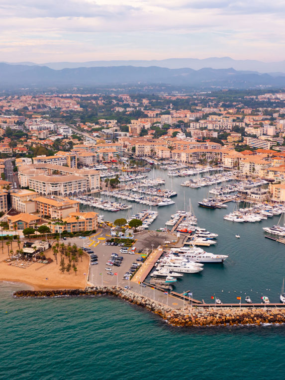 Aerial cityscape of France city Frejus with yachts in harbor