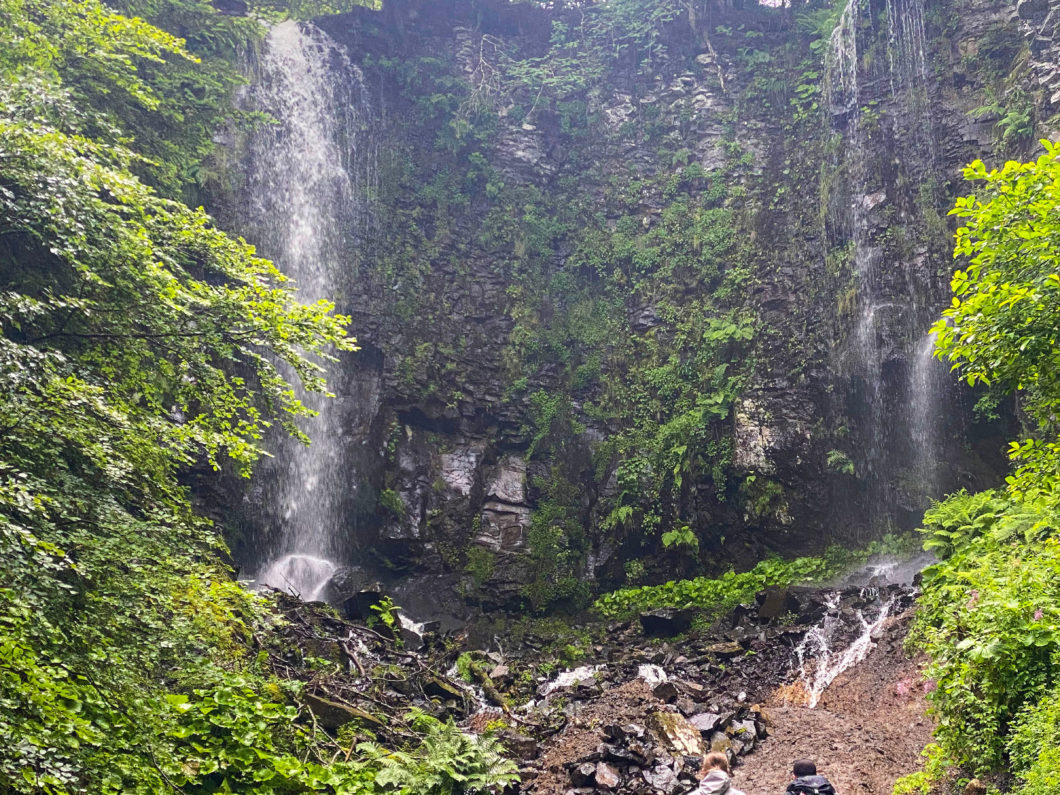 two hikers looking Saut du Loup waterfall, Mont Dore, Auvergne, France