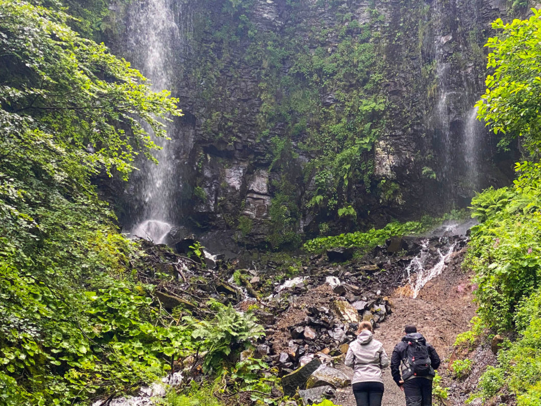 two hikers looking Saut du Loup waterfall, Mont Dore, Auvergne, France